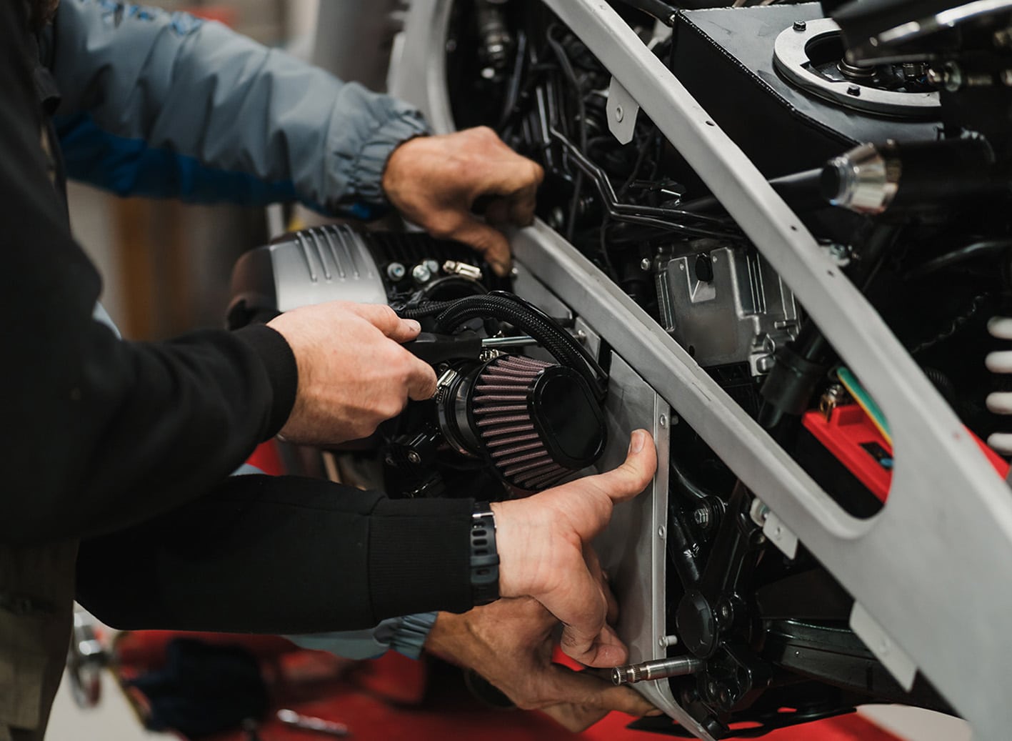 Man fixing a motorcycle in a modern workshop